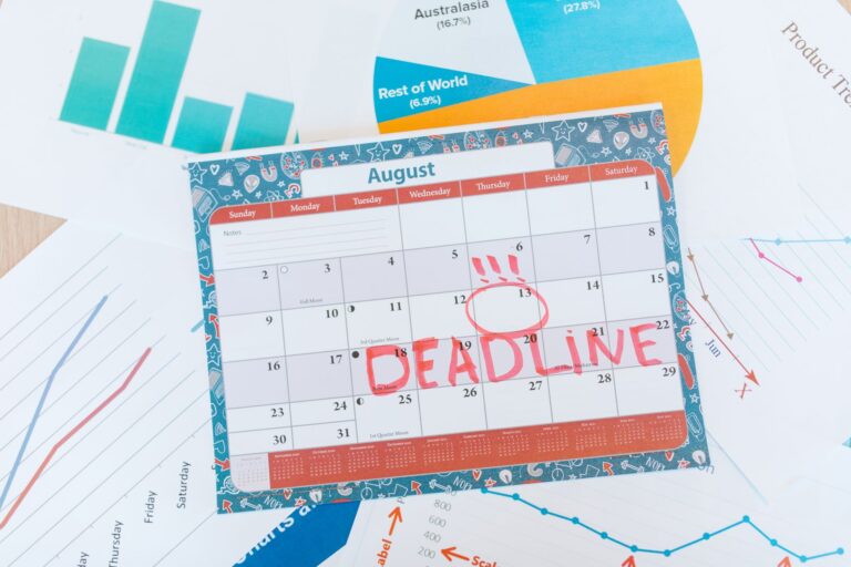 Kalender, Unterlagen und Taschenrechner auf einem Schreibtisch zur Finanzplanung