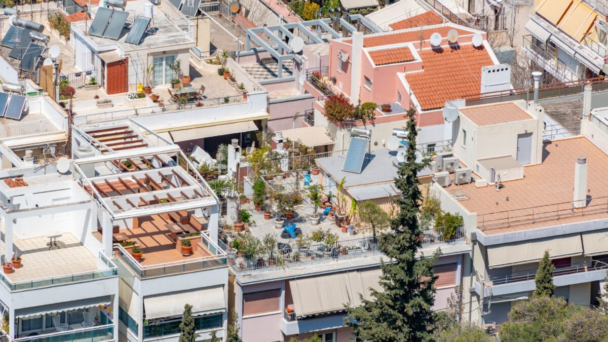 Terrasse mit verglaster Überdachung an einem Einfamilienhaus mit Garten