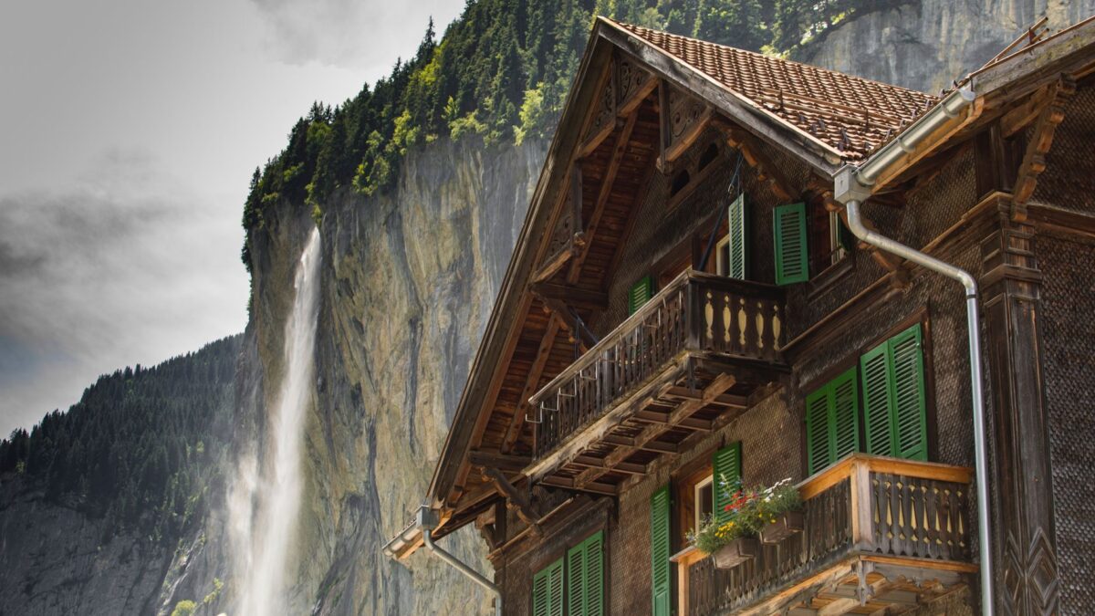 Wohnhaus mit Satteldach in einem Schweizer Dorf vor Bergkulisse