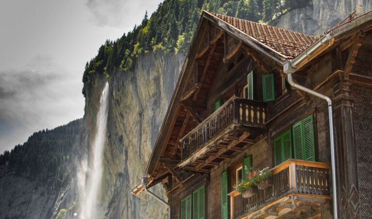 Wohnhaus mit Satteldach in einem Schweizer Dorf vor Bergkulisse